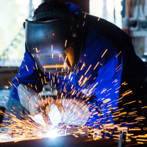 Heavy-duty dumpster manufacturing facility with steel frames being welded.