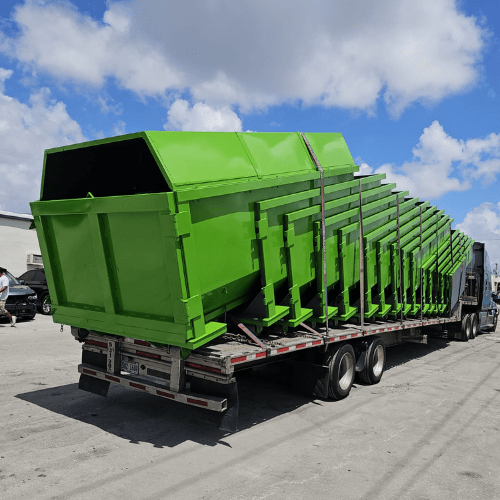 A truck delivering a roll-off dumpster to a construction site, ready for waste disposal